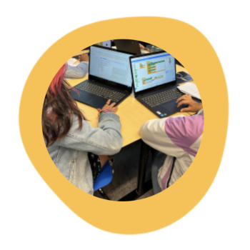 Two students between the ages of 12 and 15 code side-by-side to build a chatbot in the MIT RAISE Playground, a version of Scratch with AI extensions.